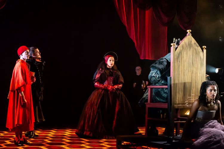 Cast of Henry VIII on stage in Tudor style costumes with modern twists including a metal details